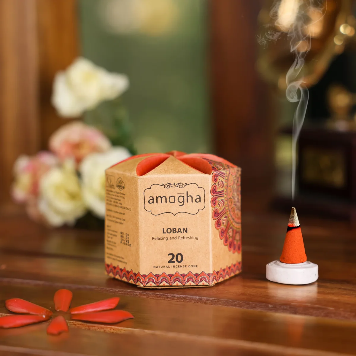 Amogha incense cone burning on an altar with smoke and flowers